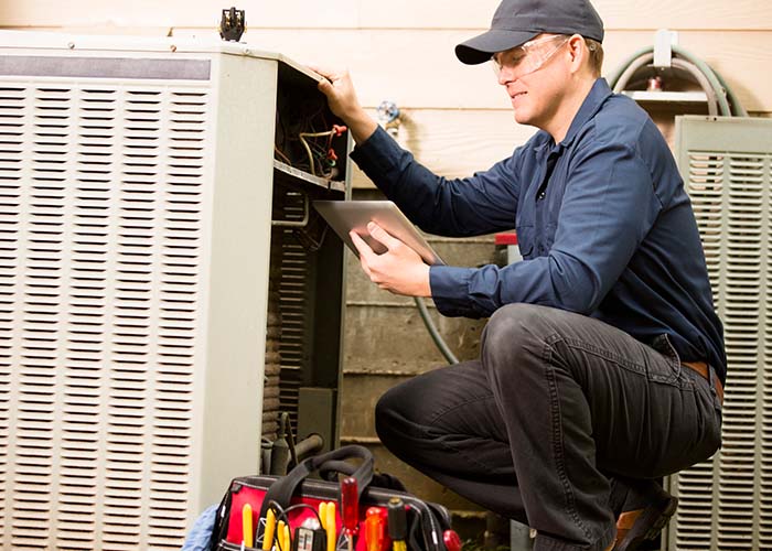 Air conditioner repairman works on home unit